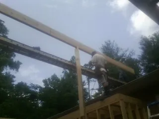 Carpenter setting a ridge beam over a new addition frame — Ice Dam Removal by Roofing Brothers in Lake Bluff