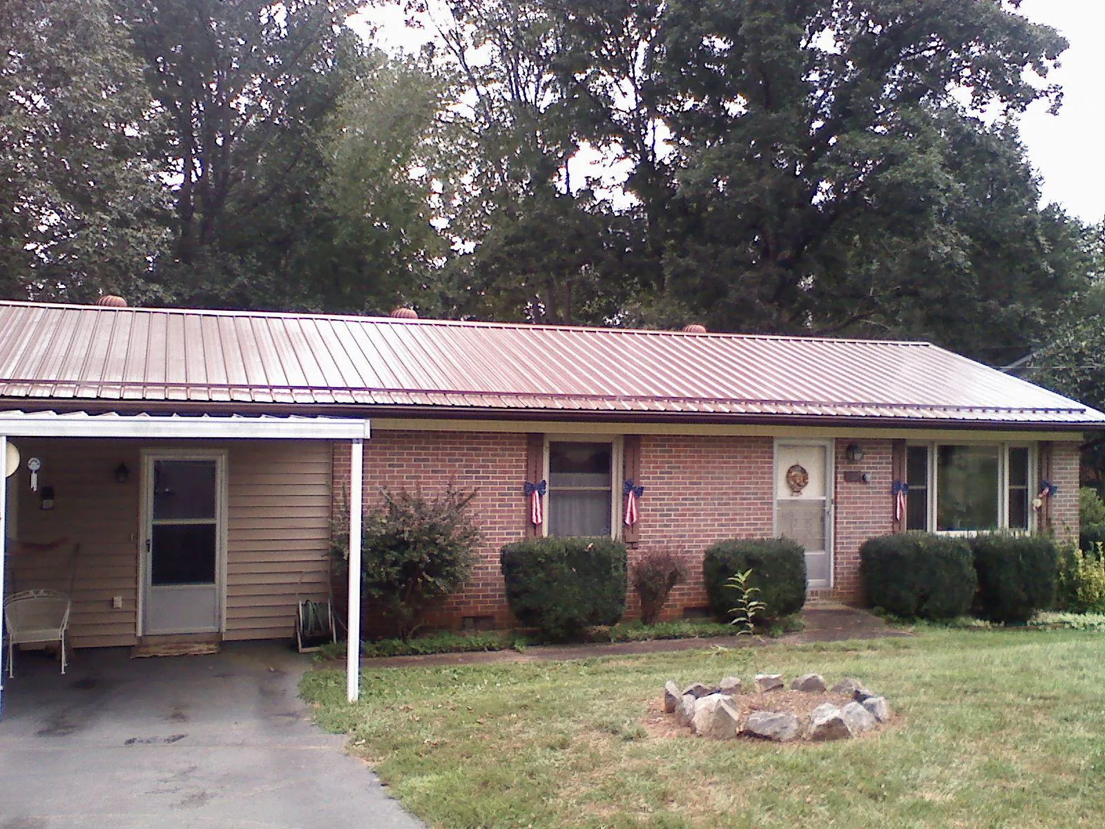 Bronze metal roof and carport on a brick ranch home — Roof Repair work by our crew in Lake Bluff
